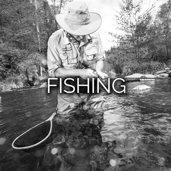 Man unhooking a fish from his hook after fly fishing in river